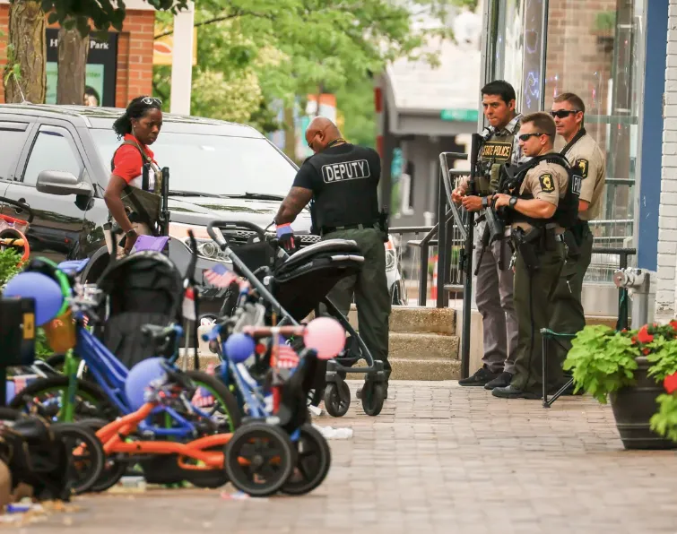 Agentes de la ley investigan la escena de un tiroteo masivo en una celebración y desfile del 4 de julio en Highland Park, Ill