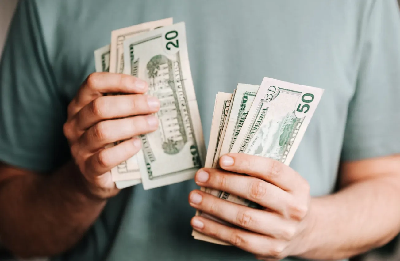 Hombre contando billetes de dólar. Foto: Pexels