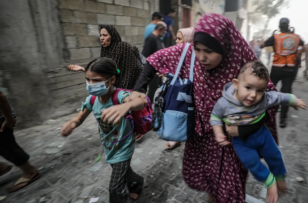 Mujeres y niños palestinos huyen tras un ataque aéreo israelí en la ciudad de Gaza, el 23 de octubre de 2023. EFE/EPA/MOHAMME